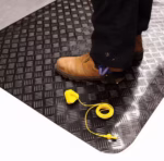 Tapis industriel ESD antifatigue noir à motif tôle larmée Senso Dial avec bordures jaunes de sécurité.