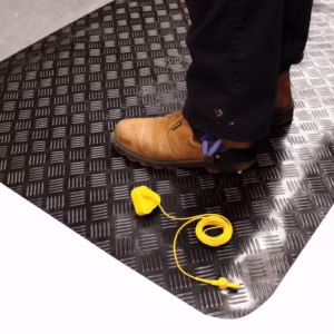 Tapis industriel ESD antifatigue noir à motif tôle larmée Senso Dial avec bordures jaunes de sécurité.